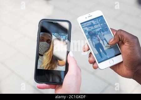 Junge gemischte Rennen Paar Selfies auf Handy-Bildschirme. Nur Hände. Weitwinkelansicht. Stockfoto