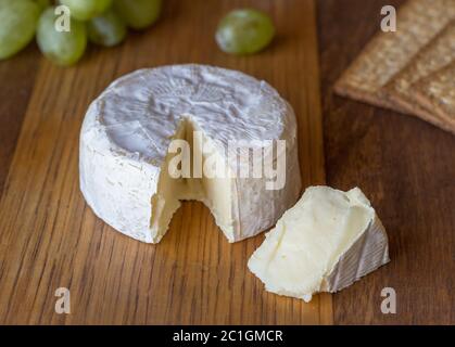 Camembert Käse und Keil auf Holzbrett Stockfoto