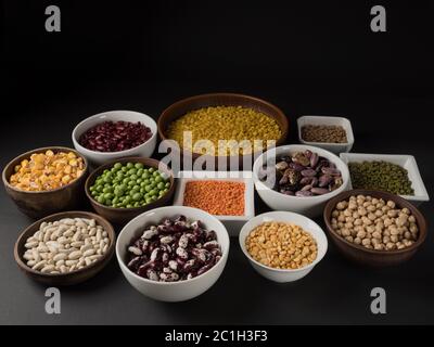 Organische Hülsenfrüchte. Schwarzer Hintergrund. Verschiedene Sorten von Erbsen, Bohnen und Linsen. Stockfoto