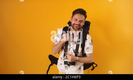 Tanzender glücklicher Rucksacktourist - kaukasischer bärtiger Reisender. Urlaub und Reisekonzept. Stockfoto
