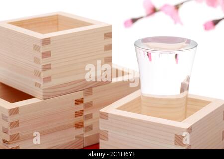 Japanische Holzkiste Masu mit Sake auf weißem Hintergrund Stockfoto