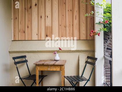 Schöne gemütliche Terrasse oder Balkon mit einem kleinen Tisch, Stuhl und Blumen. Getonten Bild Stockfoto