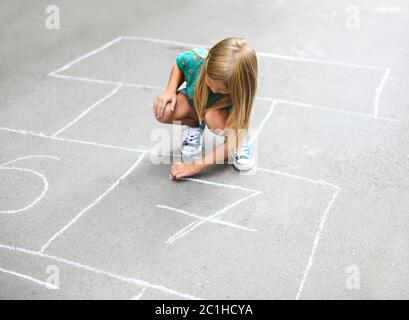 Kind spielt im Freien auf dem Spielplatz hopscotch Stockfoto