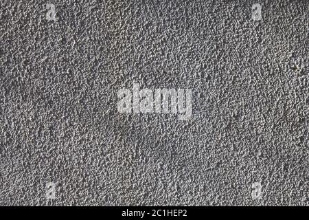 Struktur aus grauem grobkörnigem Stuck auf der verputzten Wandfläche, abstrakter Hintergrund für Design. Stockfoto