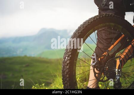 Nahaufnahme der Hinterrad-Kassette vom Mountainbike auf die Landschaft und grünes Gras Stockfoto