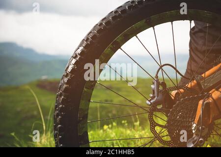 Nahaufnahme der Hinterrad-Kassette vom Mountainbike auf die Landschaft und grünes Gras Stockfoto