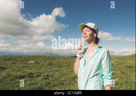 Fitness-Läufer Frau schließt die Augen und hört Musik über die Natur. Portrait von schönen Mädchen tragen Kopfhörer Ohrhörer und Stockfoto