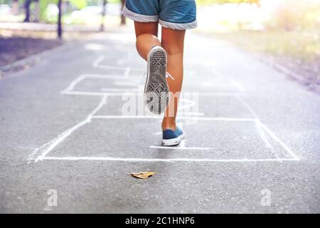 Kind spielt im Freien auf dem Spielplatz hopscotch Stockfoto