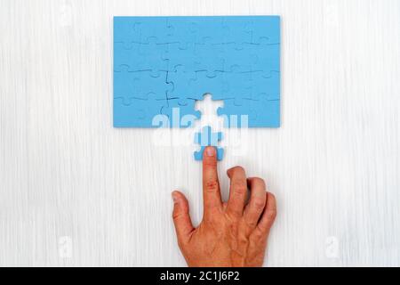 Hand legte das letzte Stück Puzzle Stockfoto