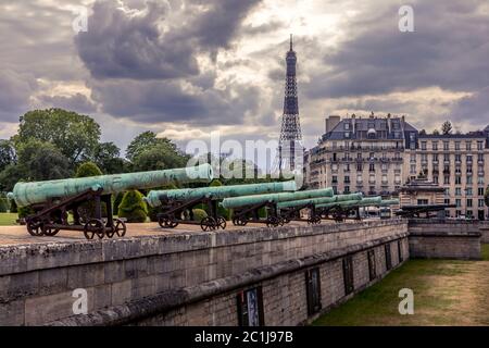 Paris, Frankreich - 10. Juni 2020: Die Kriegskanonen am Eingang des Invalidengebäudes und der Eiffelturm im Hintergrund Stockfoto