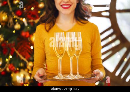 Glückliche Frau mit einem Glas Champagner auf silbernem Tablett Stockfoto