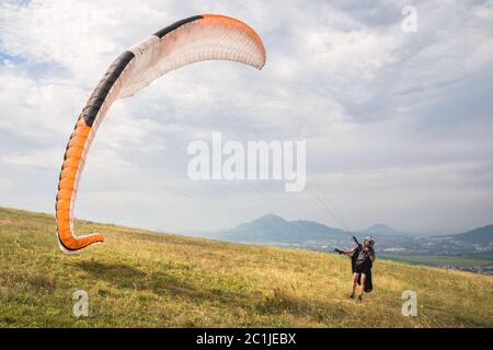 Der Gleitschirm öffnet seinen Fallschirm, bevor er vom Berg im Nordkaukasus abheben kann. Den Fallschirmflügel mit ai füllen Stockfoto