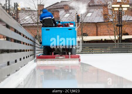 Eisvorbereitung auf der Eisbahn zwischen den Sitzungen am Abend im Freien / Rückansicht Stockfoto