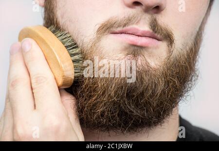 Hand der Friseur bürsten Bart. Barbershop Kunden, Vorderansicht. Bart Pflege Tipps für Anfänger. Stockfoto