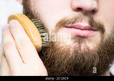 Hand der Friseur bürsten Bart. Barbershop Kunden, Vorderansicht. Bart Pflege Tipps für Anfänger. Stockfoto