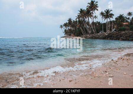 Wunderschöner und ruhiger tropischer Strand voller toter Korallenriffstücke. Ökosystem durch globale Erwärmung beschädigt. Secret Madiha Strand in Sri Lanka. Stockfoto