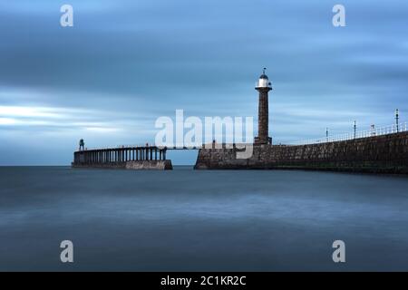 Whitby, UK - Mär 2020: Lange Exposition der einströmenden Flut in der Nähe der Pier in Whitby Bay Stockfoto