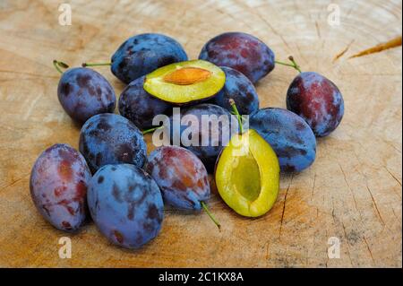 Frische Pflaumen auf einem Holzteller Stockfoto