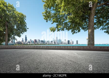 Asphaltstraße durch Garten mit Skyline Stockfoto