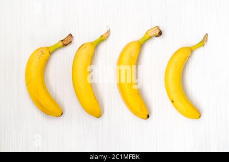 Vier frische Bananen auf Holztisch Stockfoto