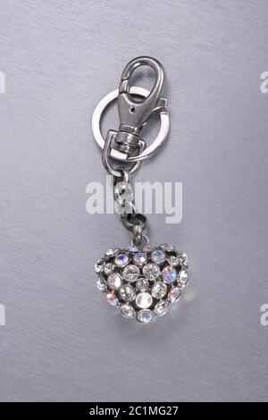 Schlüsselanhänger Herz mit funkelnden Edelsteinen auf Stahl Hintergrund Stockfoto