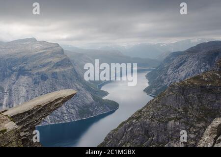 Blick auf Trolltunga Klippe und See zwischen Bergen, malerische Landschaft, Schönheit in der Natur, Paradies auf Erden, Sonnentag, Odda Stockfoto