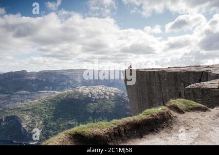 Mann sitzt auf dem Preikestolen, Pulpit Rock im schönen Norwegen Bergwelt Stockfoto