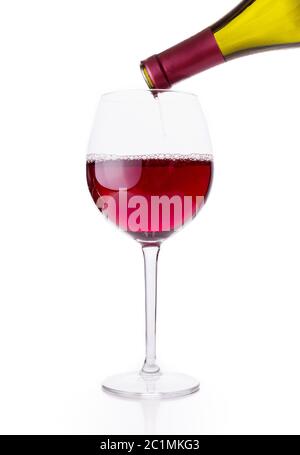 Rotwein wird in Weinglas auf weißem Hintergrund gegossen Stockfoto
