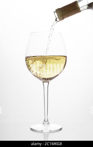Weißwein Gießen in Glas auf weißem Hintergrund Stockfoto