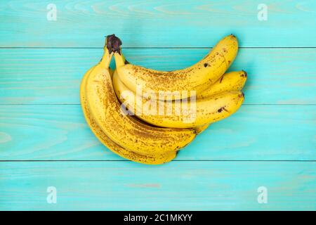 Süße Bananen auf blauem Holzhintergrund Stockfoto