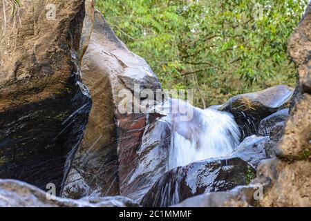 Kleine Kaskade mit klarem Wasser, das durch die Felsen fließt Stockfoto