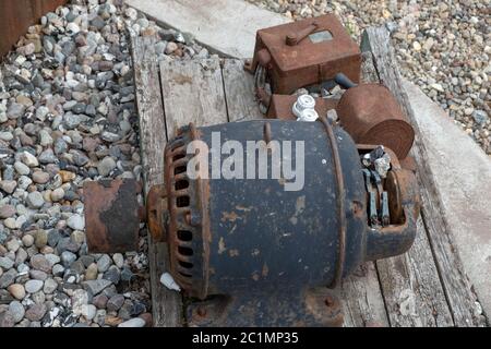 Ein alter rostiger Motor, der auf einem Holzbrett montiert ist Stockfoto