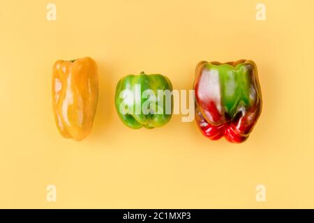Kreatives Layout von bunten Paprika auf hellorangefarbenem Hintergrund. Stockfoto