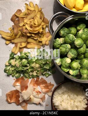 Gereinigter Rosenkohl, Brüsseler Rosenkohl, Zwiebel und Kartoffeln in einer Schüssel geschält und zusätzlich die Abfälle der Schalen Stockfoto