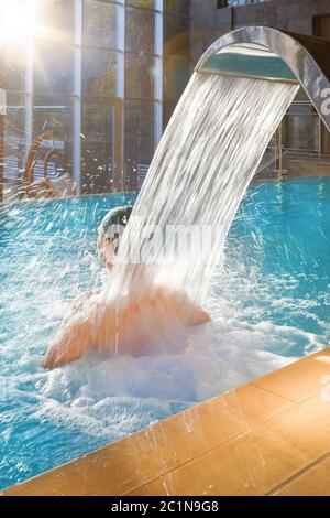 Schöner Mann, der sich im Pool entspannt. Wellness-Konzept. Stockfoto