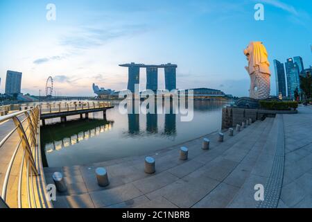 Sonnenaufgang mit Merlion Park mit Wahrzeichen Gebäude in Singapur. Stockfoto