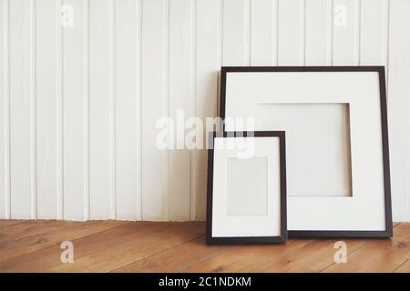 Zwei Plakate auf dem Holzboden an der weißen Wand Stockfoto