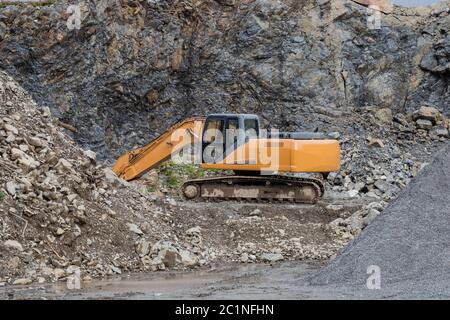 Eine große Bau-Bagger von gelber Farbe auf der Baustelle in einem Steinbruch zur Gewinnung Stockfoto