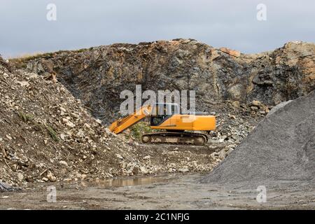 Eine große Bau-Bagger von gelber Farbe auf der Baustelle in einem Steinbruch zur Gewinnung Stockfoto