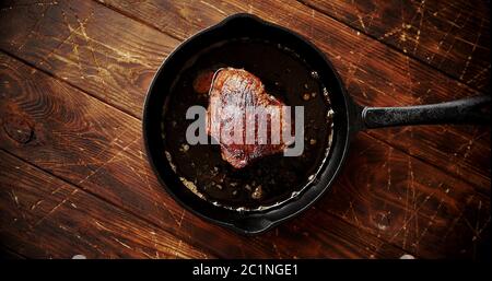 Stück Fleisch gebraten in Öl auf Pan Stockfoto