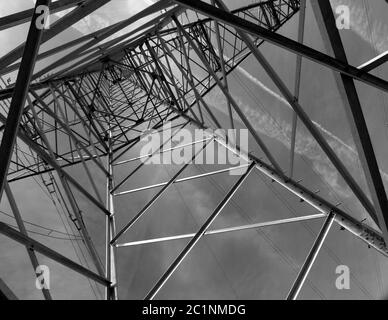 Imposanter Strommast vom Boden aus in schwarz und weiß Stockfoto