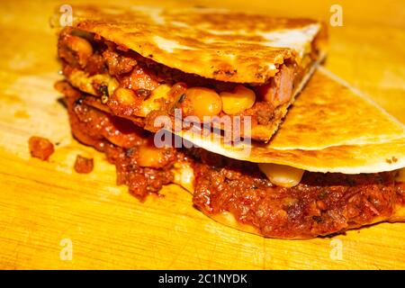 Quesadilla mit Hackfleisch, Wurst, roten Bohnen, Mais, Zwiebeln und Tomatensauce. Ein traditionelles mexikanisches Essen. Nahaufnahme Stockfoto