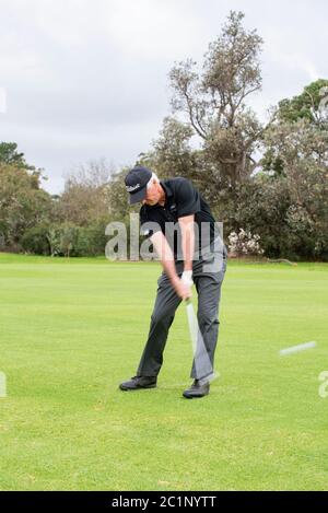 Mann auf dem Golfplatz trifft Golfball bei Impact, Victoria Australien Stockfoto