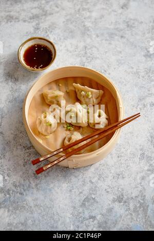 Köstliche chinesische Knödel in Holz Bambus Steamer serviert. Stockfoto