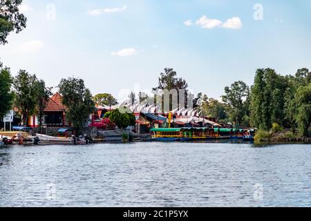 Panoramablick auf Xochimilco Kanäle oder Kanäle entlang der schwimmenden Gärten oder Chinampas in Mexiko-Stadt bei Sonnenuntergang mit ein paar Trajinera Boote in t Stockfoto