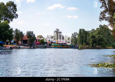 Panoramablick auf Xochimilco Kanäle oder Kanäle entlang der schwimmenden Gärten oder Chinampas in Mexiko-Stadt bei Sonnenuntergang mit ein paar Trajinera Boote in t Stockfoto