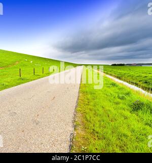 Straße entlang des schützenden Damm und Kanal Stockfoto