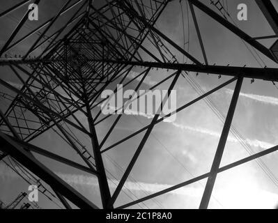 Imposanter Strommast vom Boden aus in schwarz-weiß 2 Stockfoto