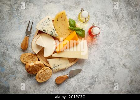 Verschiedene Käsesorten auf rustikalen Holzbrett serviert. Stockfoto