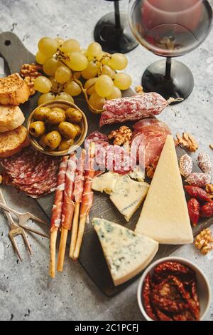 Kalte Snacks board mit Fleisch, Trauben, Wein, verschiedene Käsesorten Stockfoto